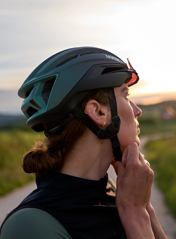 Rowerzystka zapinająca kask rowerowy.