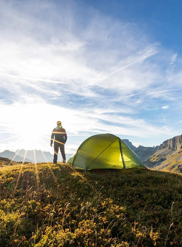 Widok na turystę oraz zielony namiot Exped.