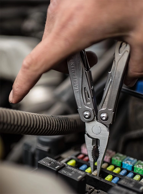 Multitool Letherman podczas naprawy samochodu.